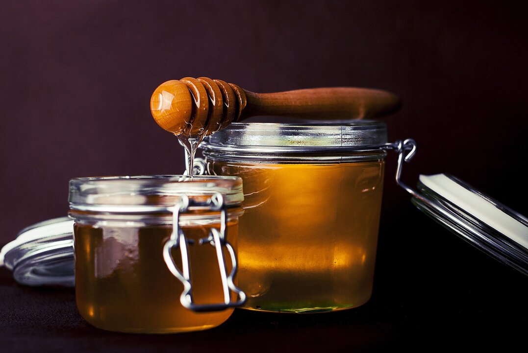 Yogurt con colata di miele e barattolo accanto